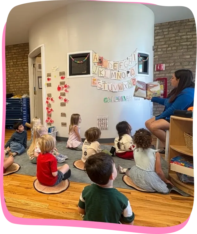 A teacher reads to preschoolers seated in a circle at Songbird Academy